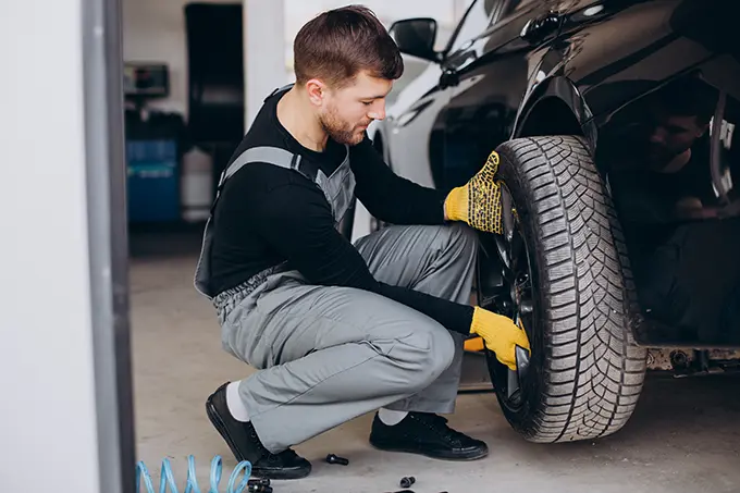 a mechanic fixing a new Tyre. replaces old flat tyre DM tyres
