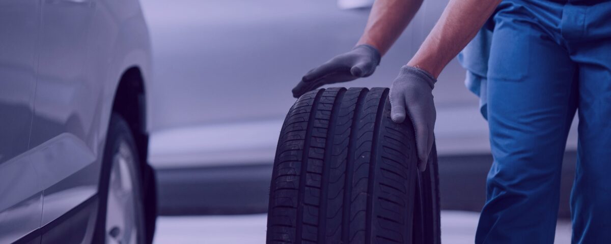 business car repairing mechanic holding tire-repair-garage-replacement-winter-summer-tires-on tyre change and car Tyre Valve repair shop