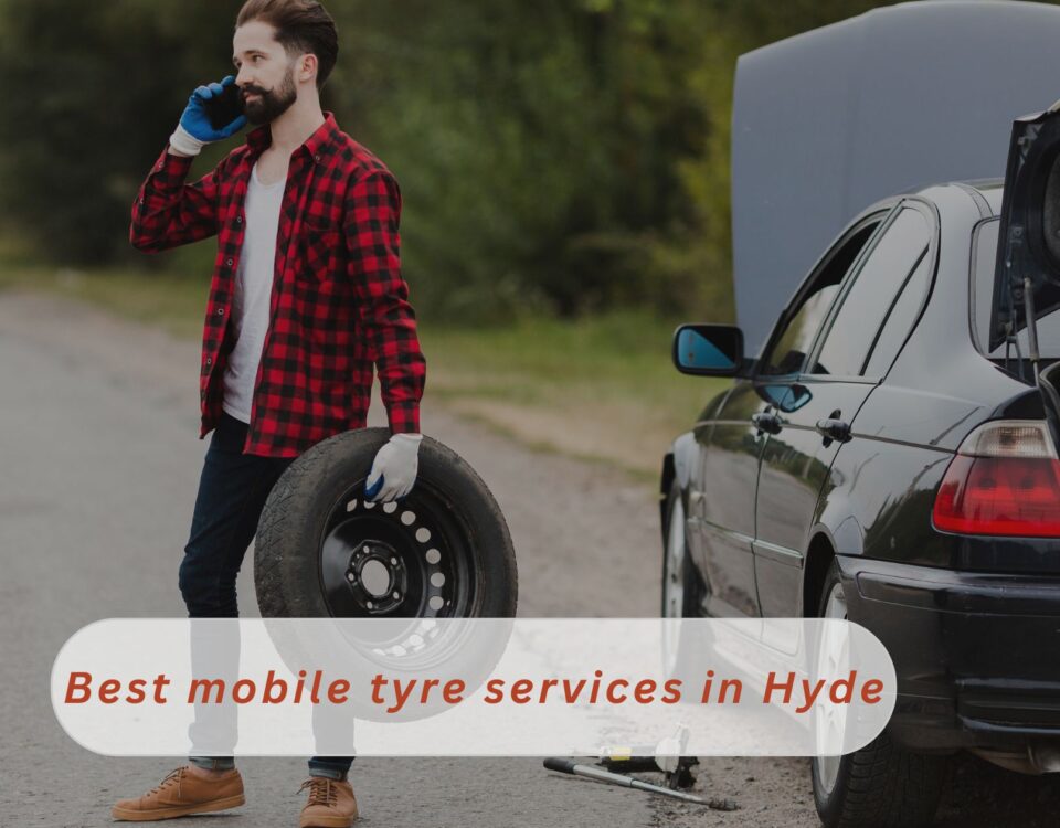 A Handsome guy is busy on phone holding a tyre calling a local mobile tyre services in Hyde